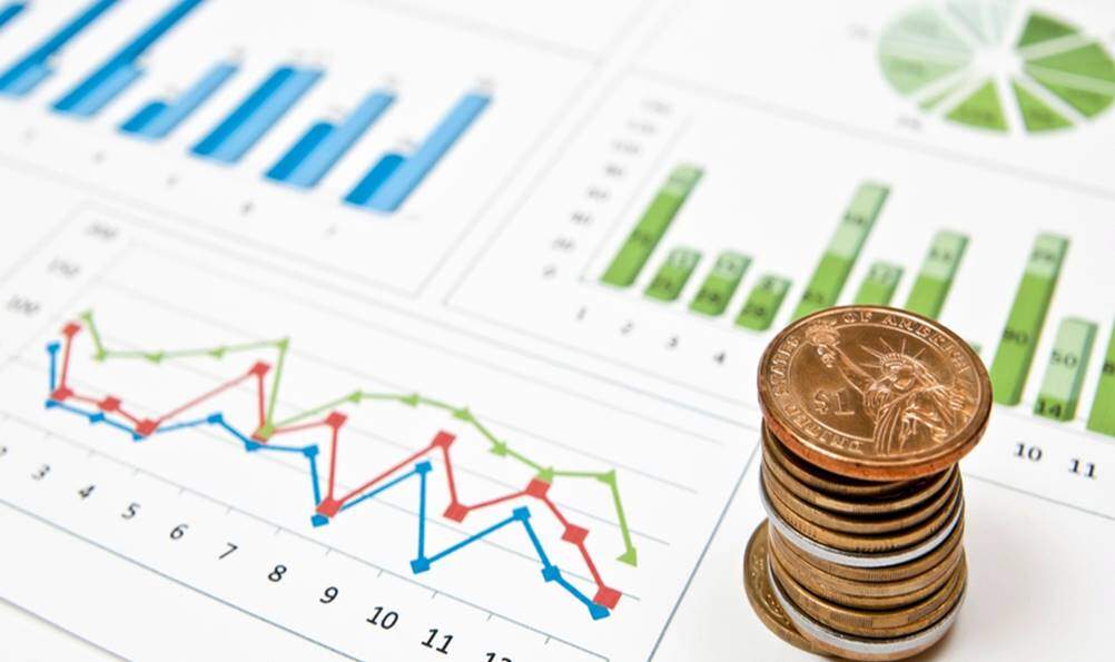 Foto mostrando moedas e gráficos usados na Gestão Financeira 