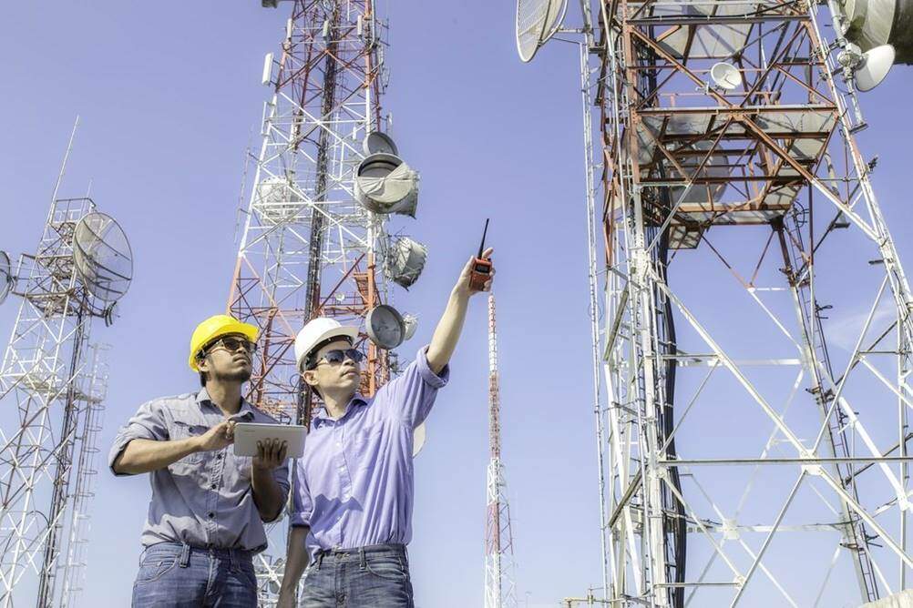 Homens trabalhando em torres de comunicação, um dos tipos de Engenharia