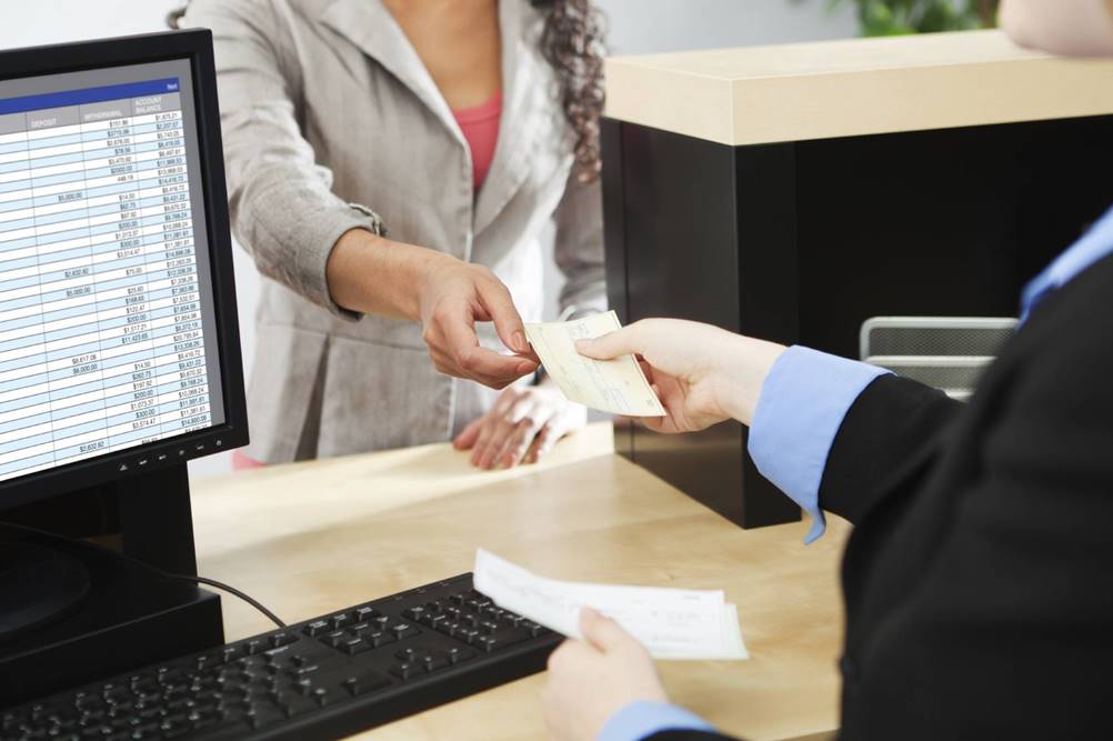 Foto de mulher entregando cheque a ser computado no controle de cheques